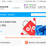 Сотрудник медицинского учреждения стоит у стойки регистрации, а рядом с ним — большая коробка с бахилами в упаковках.